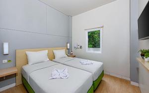 a bedroom with a large bed with white sheets and a window at IXO Bekasi in Bekasi +149 photos