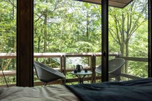 ein Schlafzimmer mit einem Bett und zwei Stühlen und einem Tisch in der Unterkunft blue in green 飯田高原 cottage and cafe in Iida + 9 Fotos