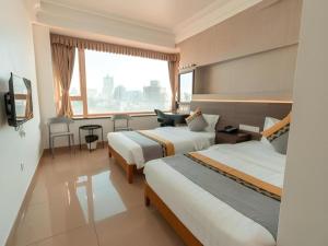 a hotel room with two beds and a window at Grand Harbour Hotel in Macau