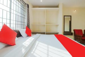 a bedroom with a large bed with red pillows at Hotel O Anu Grand in Visakhapatnam
