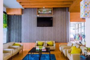 シーラーチャーにあるThe Loft Seaside Sriracha Hotelのリビングルーム(ソファ、壁掛けテレビ付)