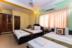 a bedroom with two beds and a window at Happy Zone Hostel in Siem Reap