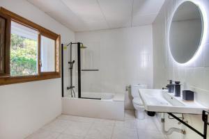 a bathroom with a toilet and a sink and a mirror at Pescadors in Pals +24 photos
