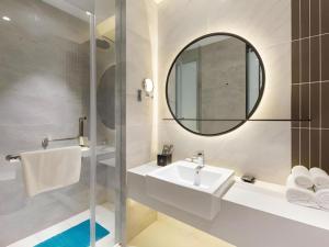 上海市にあるMagnotel Hotel Shanghai Jinjiang Park Branchの洗面台と鏡のあるバスルーム