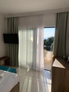 a hotel room with a bed and a view of a balcony at REZEVICI BOUTIQUE VILLA in Petrovac na Moru