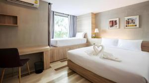 a hotel room with a large bed and a window at B2 Ubon Premier Hotel in Ubon Ratchathani +22 photos