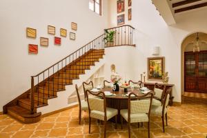 a dining room with a table and chairs and a staircase at La Morena by The Blue Kite - Luxurious & Spacious 4 BHK villas in Assagao, Private Pool, Balcony, Kitchen, Patio and Security in Assagao