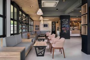 a restaurant with couches and tables and chairs at R Photo Hotel in Nakhon Phanom