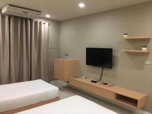a bedroom with a bed and a flat screen tv at M-one Residence in Ban Kohong
