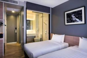a bedroom with two beds and a bathroom at R Photo Hotel in Nakhon Phanom