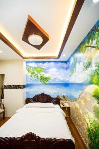 a bedroom with two beds and a painting on the wall at Phuong Linh Hotel in Ho Chi Minh City