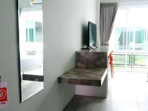 a living room with a bench and a mirror at Kosit One Hotel in Ban Bung Sam Phan Nok