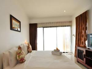 a bedroom with a large bed and a television at Villa Phra Chan Resort in Ban Pak Nam Khem Nu