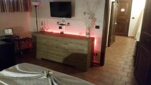 a room with a dresser with a tv on the wall at Villa Laura B&B in Fossano