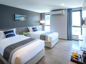 a hotel room with two beds and a television at IWISH Hotel Bangkok in Ban Bang Khen (1) +116 photos