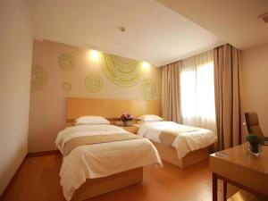 a hotel room with two beds and a window at GreenTree Inn Shanghai National Convention and Exhibition Center Huaxiang Road in Shanghai +182 photos