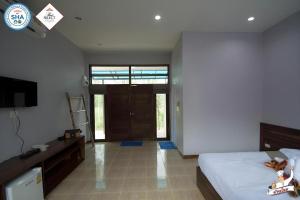 Un dormitorio con una cama, un escritorio y un televisor. en Baan Home Resort, en Kalasin