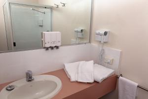 a bathroom with a sink and a mirror at White Lace Motor Inn in Mackay +21 photos
