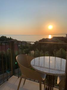 a table and chairs on a balcony with the sunset at REZEVICI BOUTIQUE VILLA in Petrovac na Moru