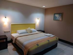 1 dormitorio con 1 cama grande y cabecero amarillo en Bintang Hotel, en Klandasan-besar 34 fotos más