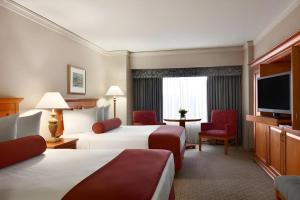 a hotel room with two beds and a flat screen tv at Harrahs Hotel Reno in Reno