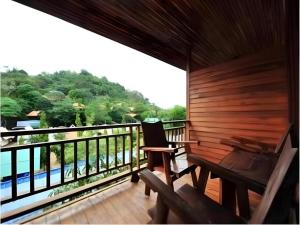 a room with a balcony with a view of the water at Phuttachot Resort in Phi Phi Don