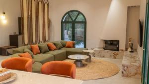 a living room with a green couch and orange chairs at Xenia Sea view Villa in Argassi