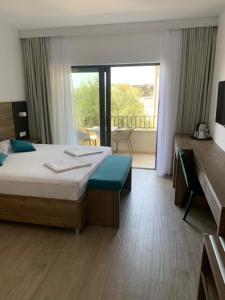 a hotel room with a bed and a large window at REZEVICI BOUTIQUE VILLA in Petrovac na Moru