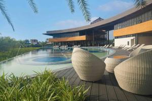 a resort with a pool and chairs and a building at Seafront Villa Laiya in Subuquin