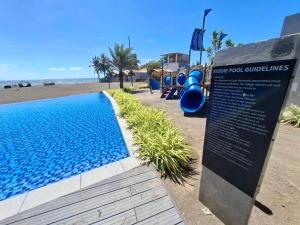 a sign next to a playground next to a beach at Seafront Villa Laiya in Subuquin