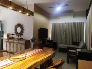 a living room with a wooden table and a couch at Seafront Villa Laiya in Subuquin