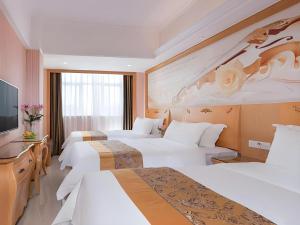 une chambre d'hôtel avec trois lits et une télévision à écran plat dans l'établissement Vienna Classic Hotel Guangdong Yangxi Moon Bay, à Dabang 139 autres photos