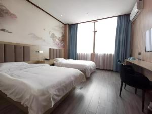 a hotel room with two beds and a desk at Thank Inn Hotel Jiangsu Suzhou Luzhi Ancient Town Scenic Area in Suzhou