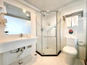 a bathroom with a shower and a toilet and a sink at GreenTree Inn Urumqi South Xinhua Road Hotel in Ürümqi