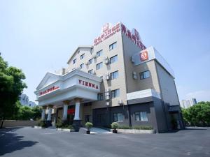 ein Hotel mit einem Schild an der Vorderseite in der Unterkunft Vienna 3 Best Shanghai Baoshan Fengxiang Road in Chenjiahang