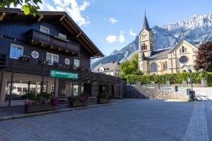 a town with a church and a building with a clock tower at Die Bergretter Appartements in Ramsau am Dachstein