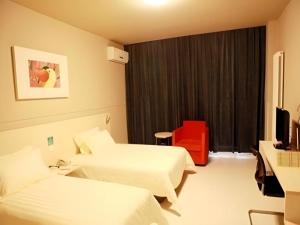 une chambre d'hôtel avec deux lits et une fenêtre dans l'établissement Jinjiang Inn Yantai Penglaige Zhonglou North Road, à Penglai