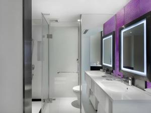 a bathroom with two sinks and a toilet and a mirror at GreenTree Alliance Hotel Guiyang Huaguo Community Central Business Zone in Guiyang +191 photos