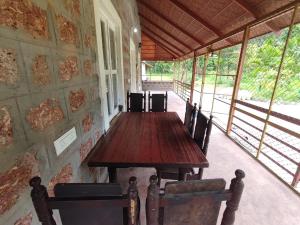 a wooden table and chairs in a room with windows at Mountain View Stay in Kushālnagar