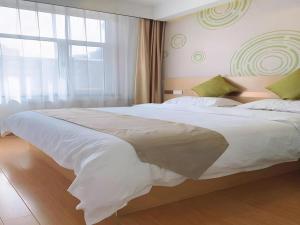 a large white bed in a bedroom with a window at GreenTree Inn Langfang GuAn County Xinyuan Street Express Hotel in Gu'an +81 photos