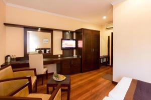 a living room with a desk and a television at Devon Hotel in Kandy