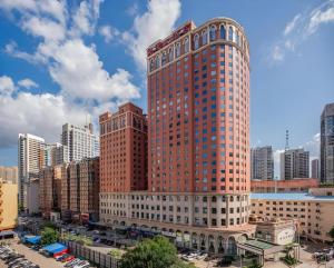 a tall red brick building in a city at Dalian Liangyun Hotel in Dalian