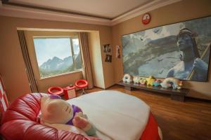 ein Baby auf einem Stuhl im Zimmer in der Unterkunft Anshan Camilla Business Hotel in Anshan