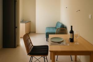 a room with a table and chairs and a bottle of wine at Mediteranno Suites in Sami