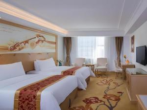 a hotel room with two beds and a television at Vienna Hotel Shenzhen Longgang Baifucheng in Longgang +229 photos