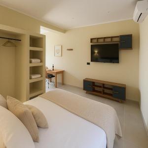 a bedroom with a bed and a flat screen tv at Mediteranno Suites in Sami