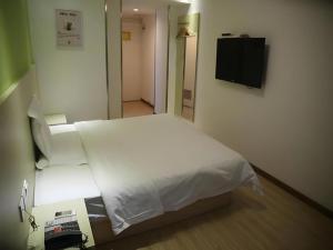 7 Days Inn Qingdao Liaoyang West Road Xinye Plaza Metro Station في تشينغداو: غرفة نوم بسرير أبيض وتلفزيون +60 صورة