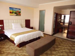 une chambre avec un lit et un banc dans l'établissement GreenTree Inn Henan Shangqiu Yongcheng Ouya Road Business Hotel, à Houling