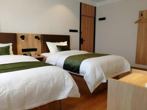 2 Betten in einem Hotelzimmer mit 2 in der Unterkunft GreenTree Inn Express Cangzhou Yunhe District Mingzhu Market in Cangzhou + 161 Fotos