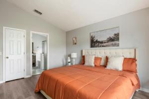 a bedroom with a large bed with an orange blanket at Chic & Cozy Hideaway in Davenport +26 photos